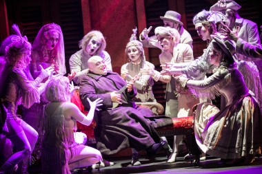 “Though I'm told it's wrong when I sing my song, she accepts, she attends, she believes, she befriends… It's a dream that's coming true, when the moon says ‘I love you’.” (Anthony Gruppuso as "Uncle Fester" sings of his "true love" for all his "Ancestors" to hear.)