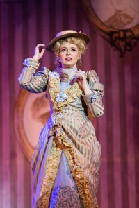 “And he might smile and take me by the hand, this summer, making me recall how lovely Love can be…” Afton Quast as “Irene Malloy” dreams of romance while proudly wearing “Ribbons Down My Back” in 3-D Theatricals’ “Hello Dolly!”