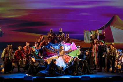 “I look handsome, I look smart—I am a walking work of art!” Justin Anthony Long as “Joseph” shows off his new multi-hued designer apparel to others in his family in 3-D Theatrical’s “Joseph & The Amazing Technicolor Dreamcoat”