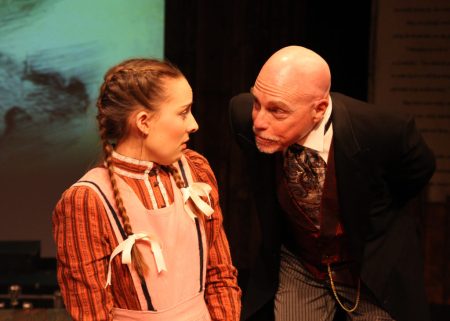 “If you say ’Come with me to Massachusetts’, then to Massachusetts we will go; we will buy dishes there (maybe even two sets,) buy the finest china then we’ll dine awhile on Crepe Suzettes!” Emma Nossal as “Beth” enjoy as lighthearted moment with Glenn Koppel as neighbor “Mr. Laurence”